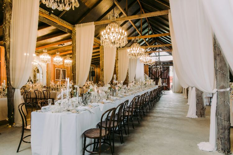 Rustic barn reception space with chandeliers at Anambah House