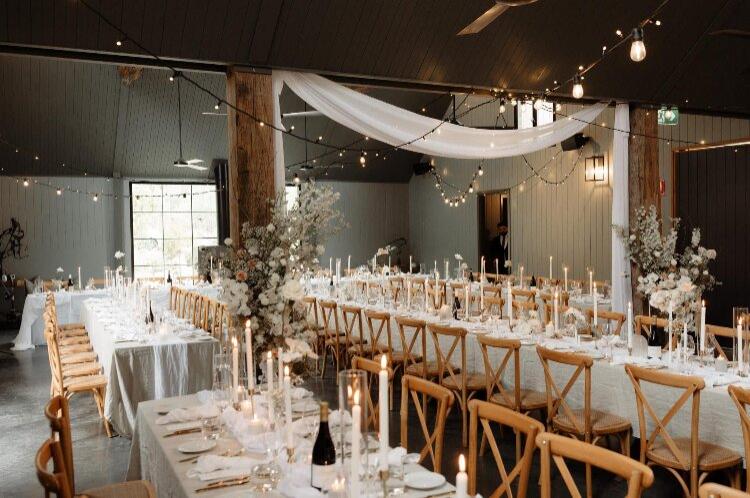 Barn reception space with long timber tables at The Woodhouse