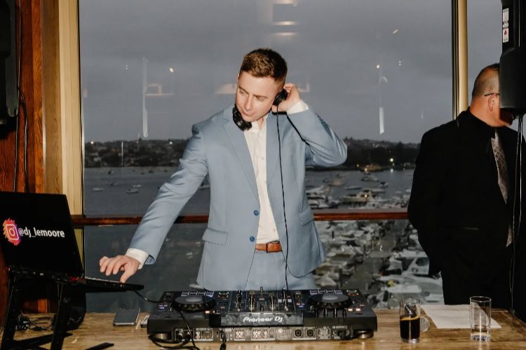 Sydney wedding DJ performing at reception with professional decks & harbour view
